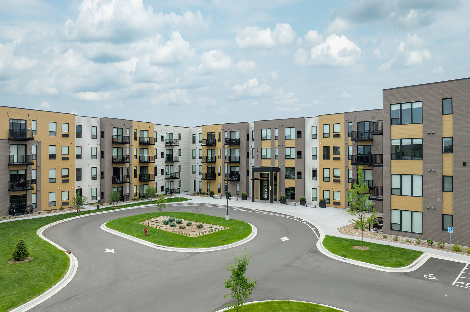 Wide-angle view of The Harlan Oakdale apartment complex with roundabout driveway