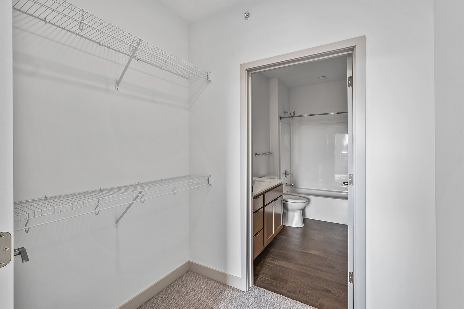 Closet with wire shelving and view into bathroom