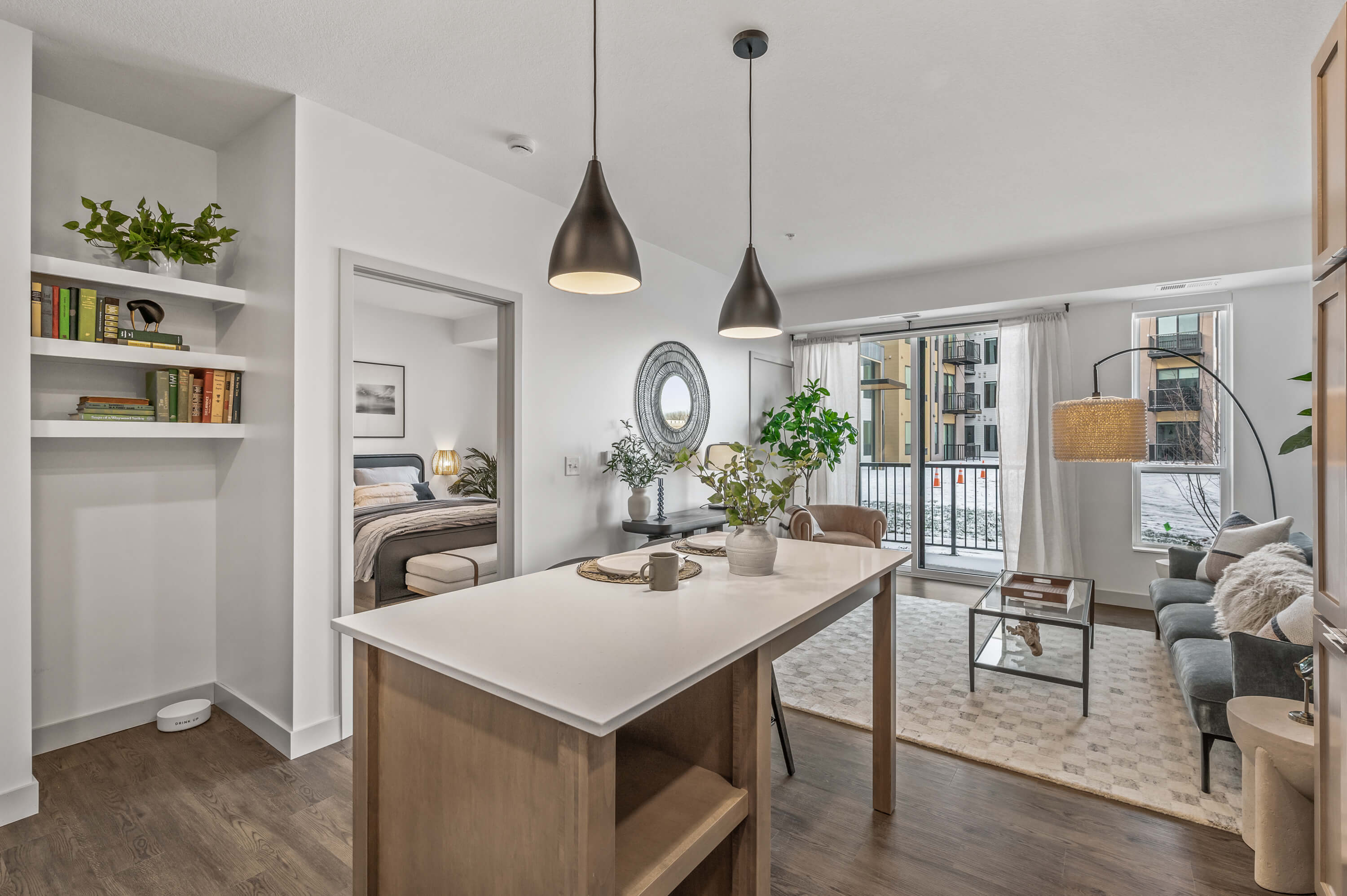 Open kitchen with modern decor and a dining island, connected to a cozy living area with large windows and natural light.