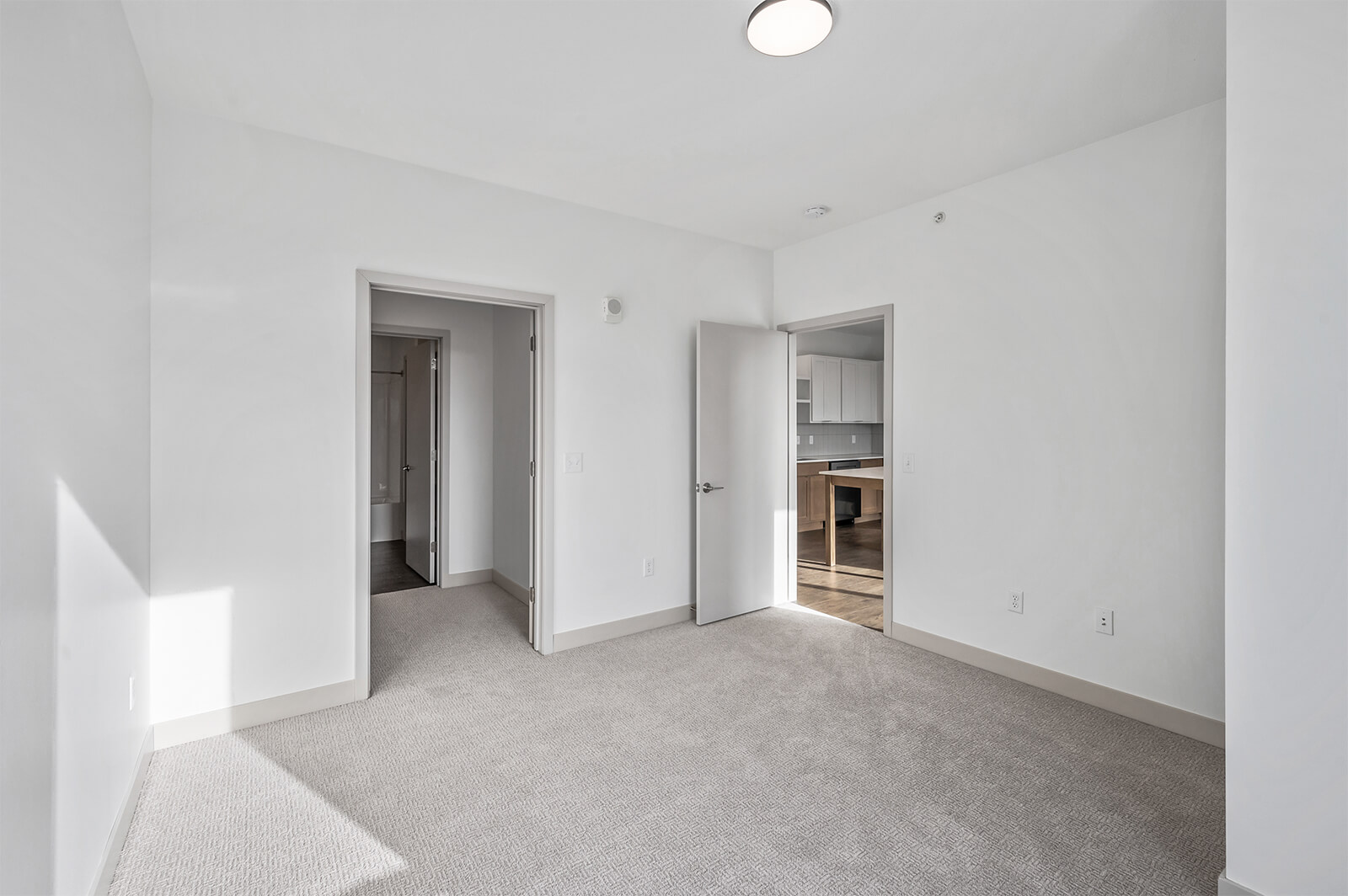 Bedroom with doorway showing view of kitchen area