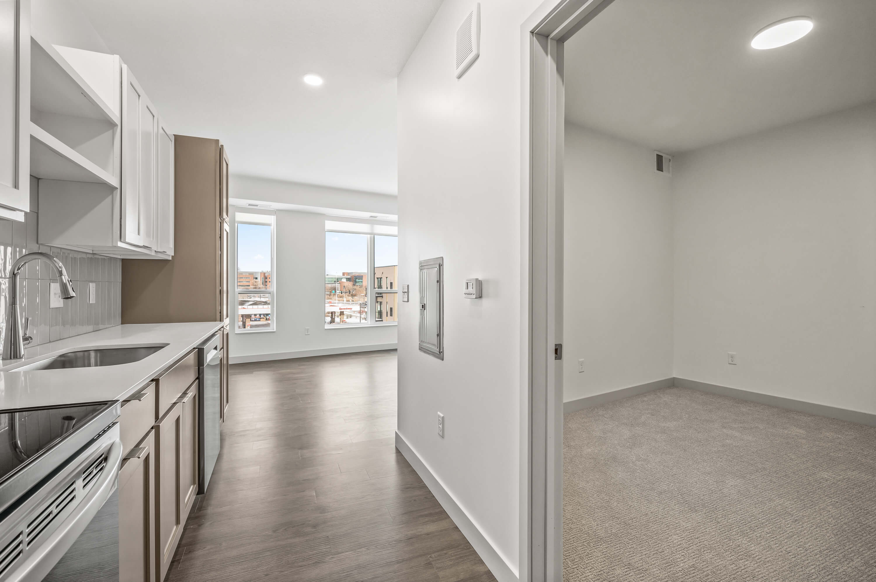 Spacious room with beige carpet, white walls, and a closet with sliding doors.