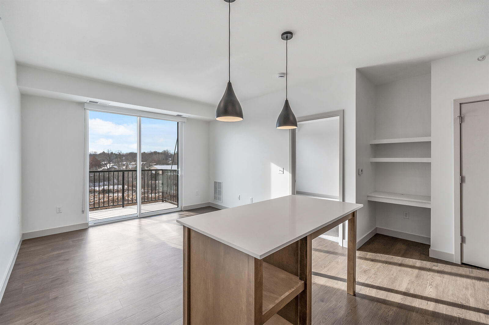 Kitchen island view with pendant lights, balcony, and built-in shelves