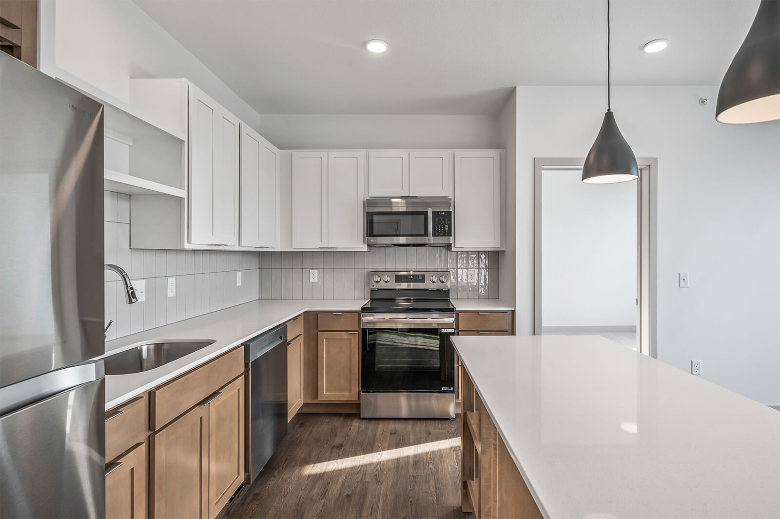Kitchen with white upper cabinets, brown lower cabinets, and stainless steel appliances