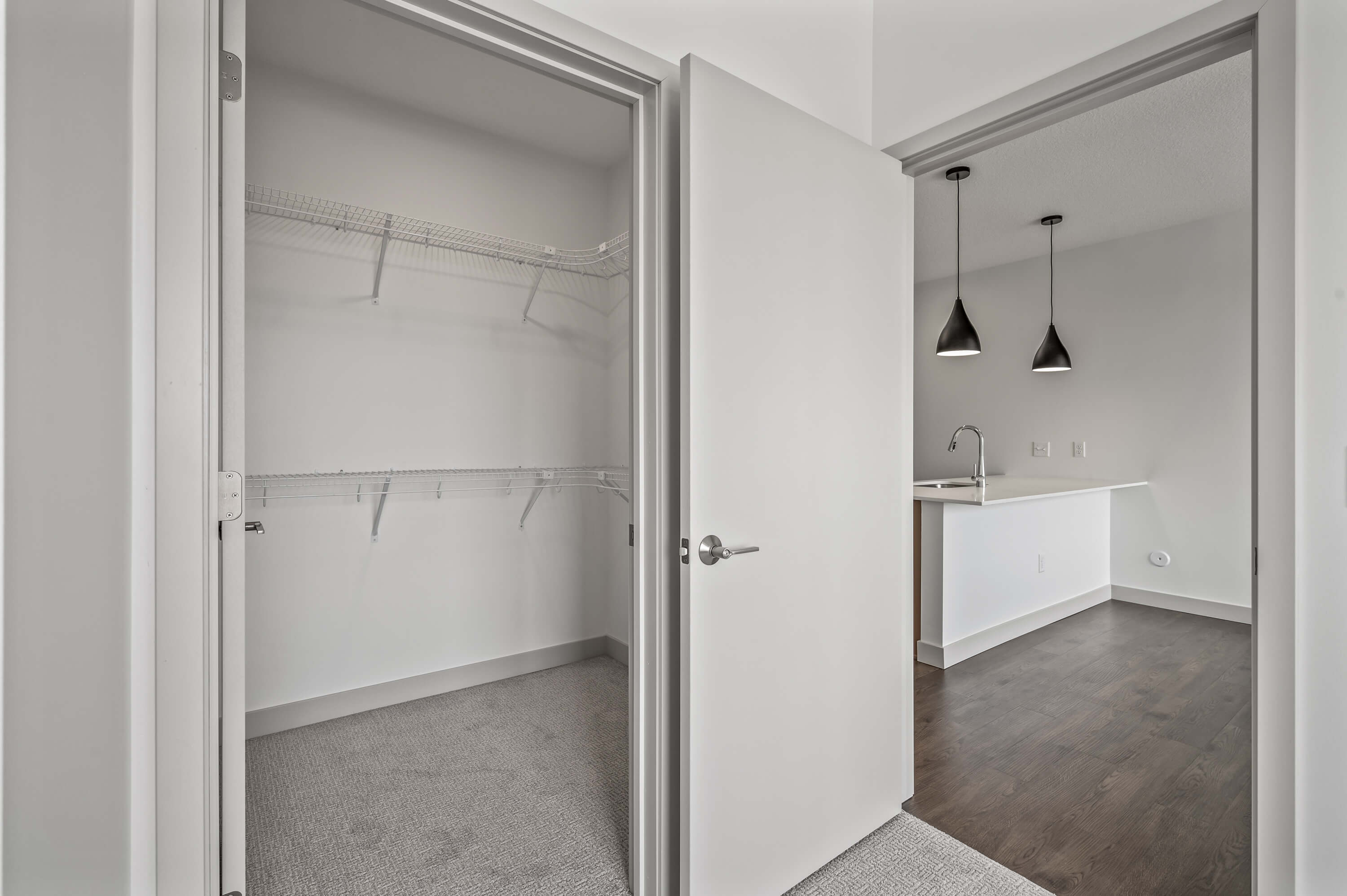 Walk-in closet with ample shelving space, located next to the kitchen and dining area.