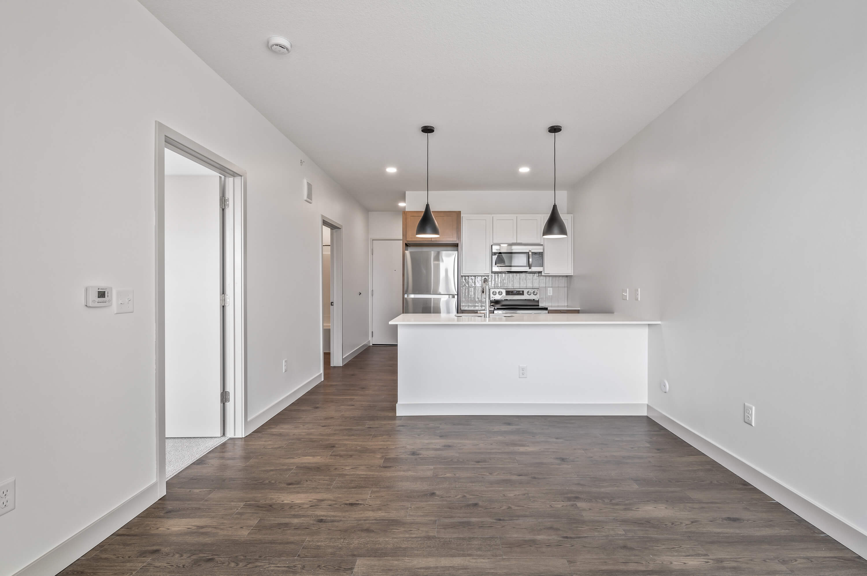 Close-up of the kitchen island with sink and countertop space, complemented by modern lighting.