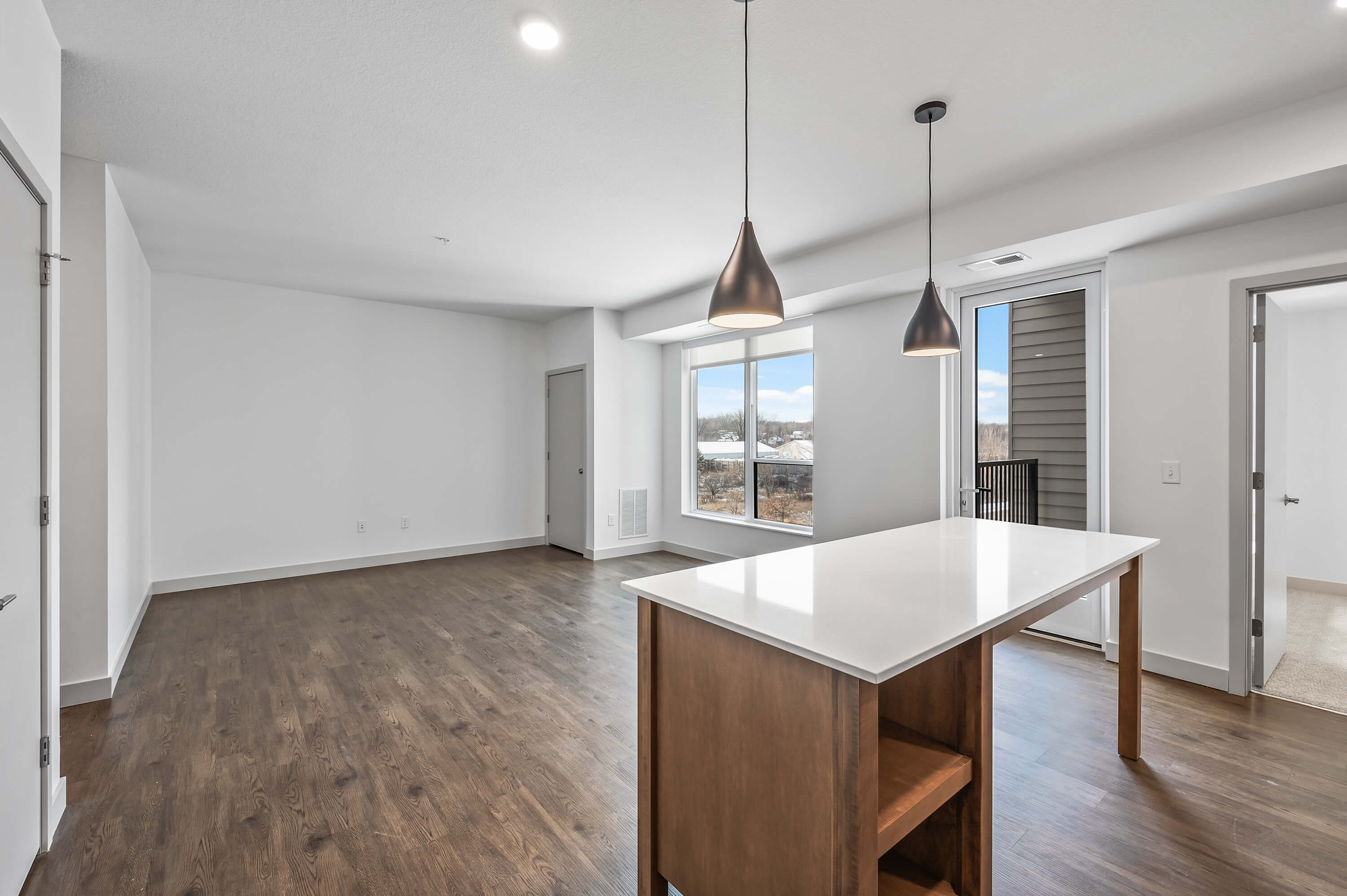 Bright kitchen area with sleek appliances, a wooden island, and clean, modern finishes.