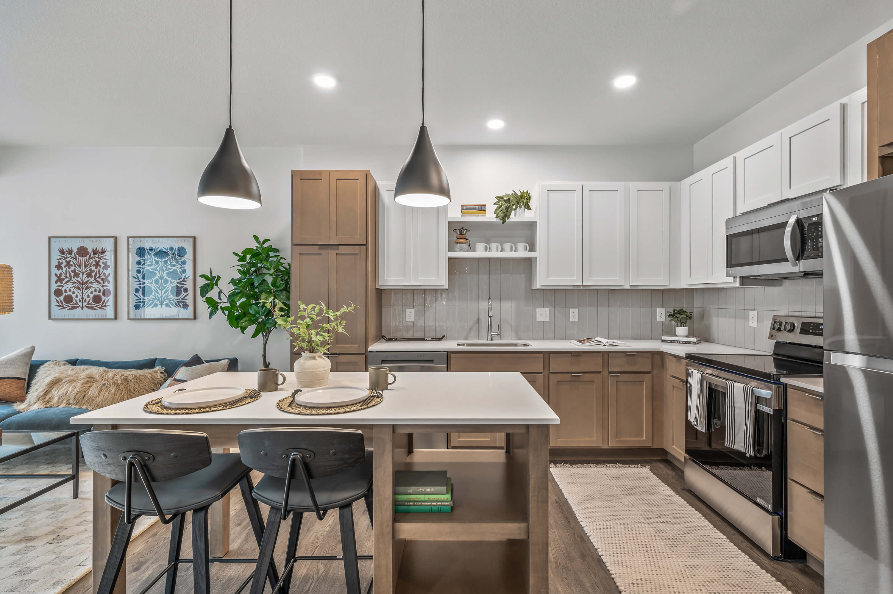 Kitchen with a mix of wood and white cabinets, stainless steel appliances, and a central island with bar seating.