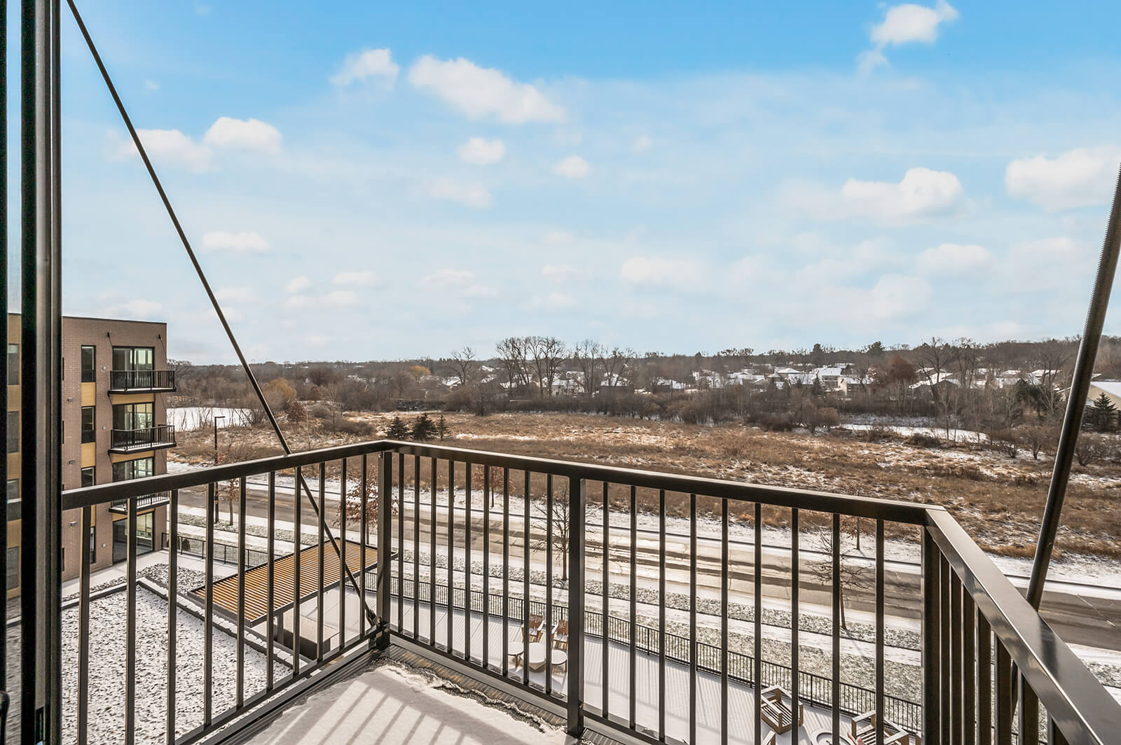 Balcony view overlooking snowy landscape and nearby buildings