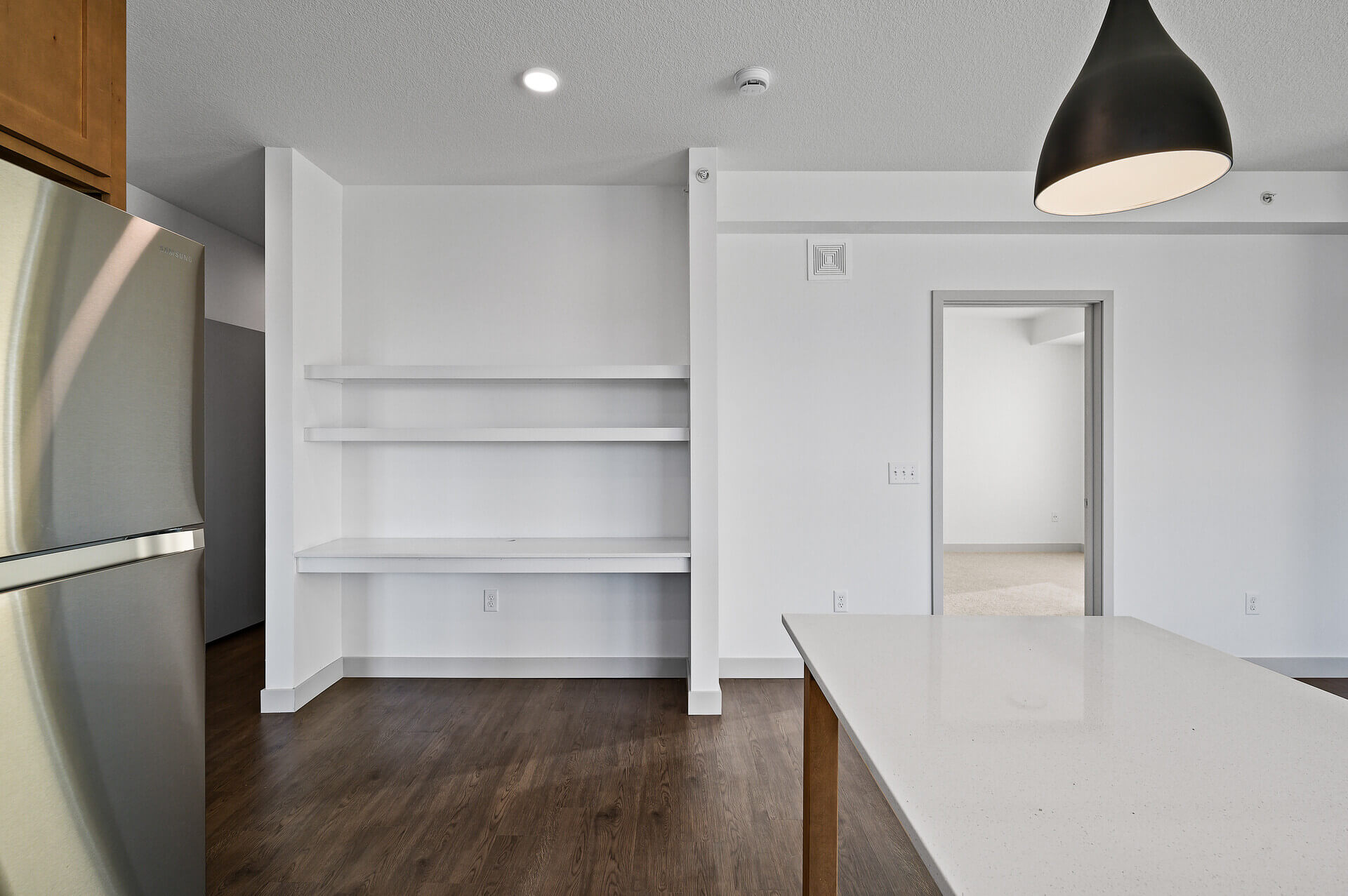 Kitchen area featuring a stainless steel refrigerator and built-in shelves.