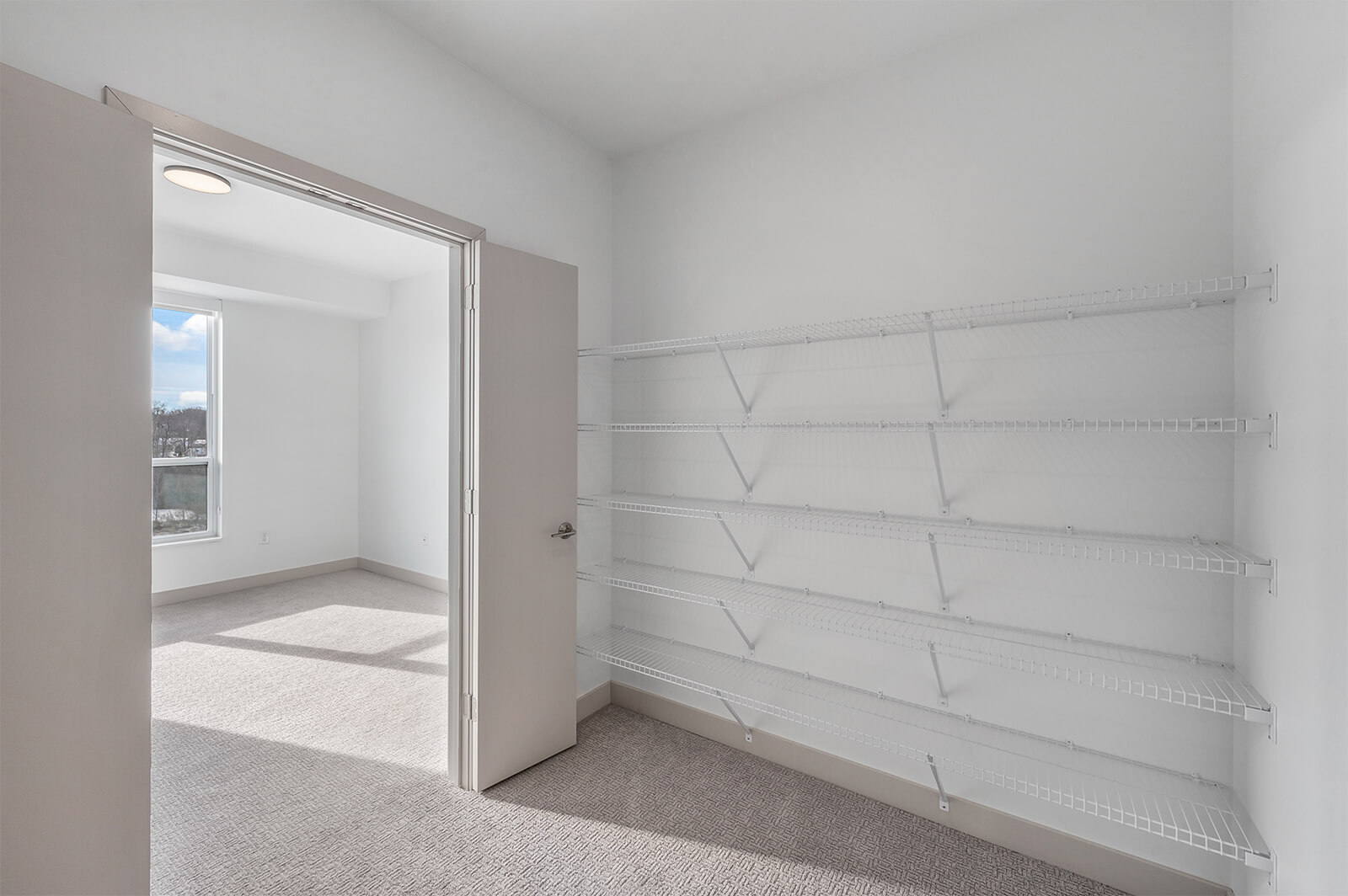 Walk-in closet with white wire shelving