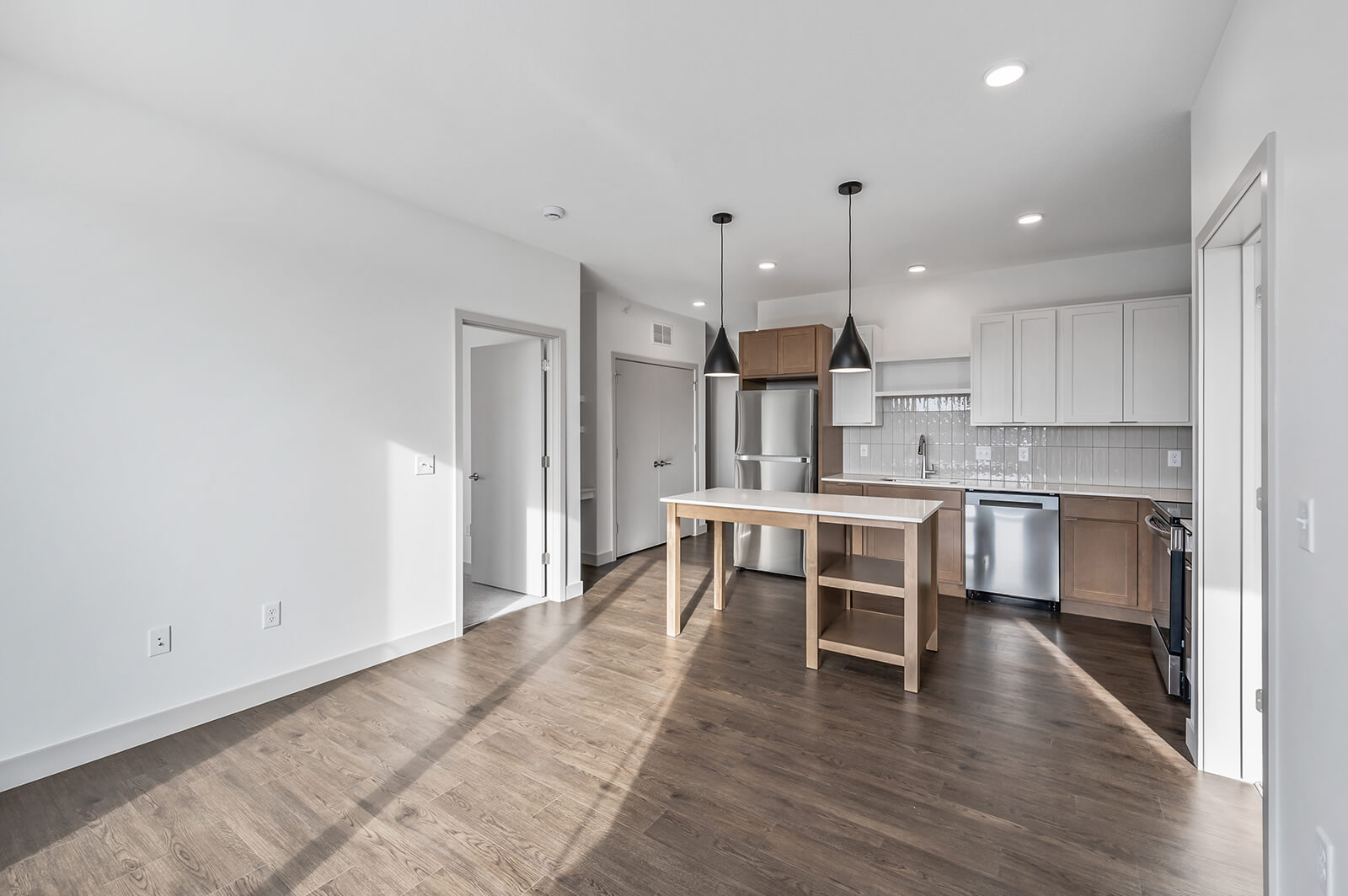Open view of kitchen and living room with wood flooring