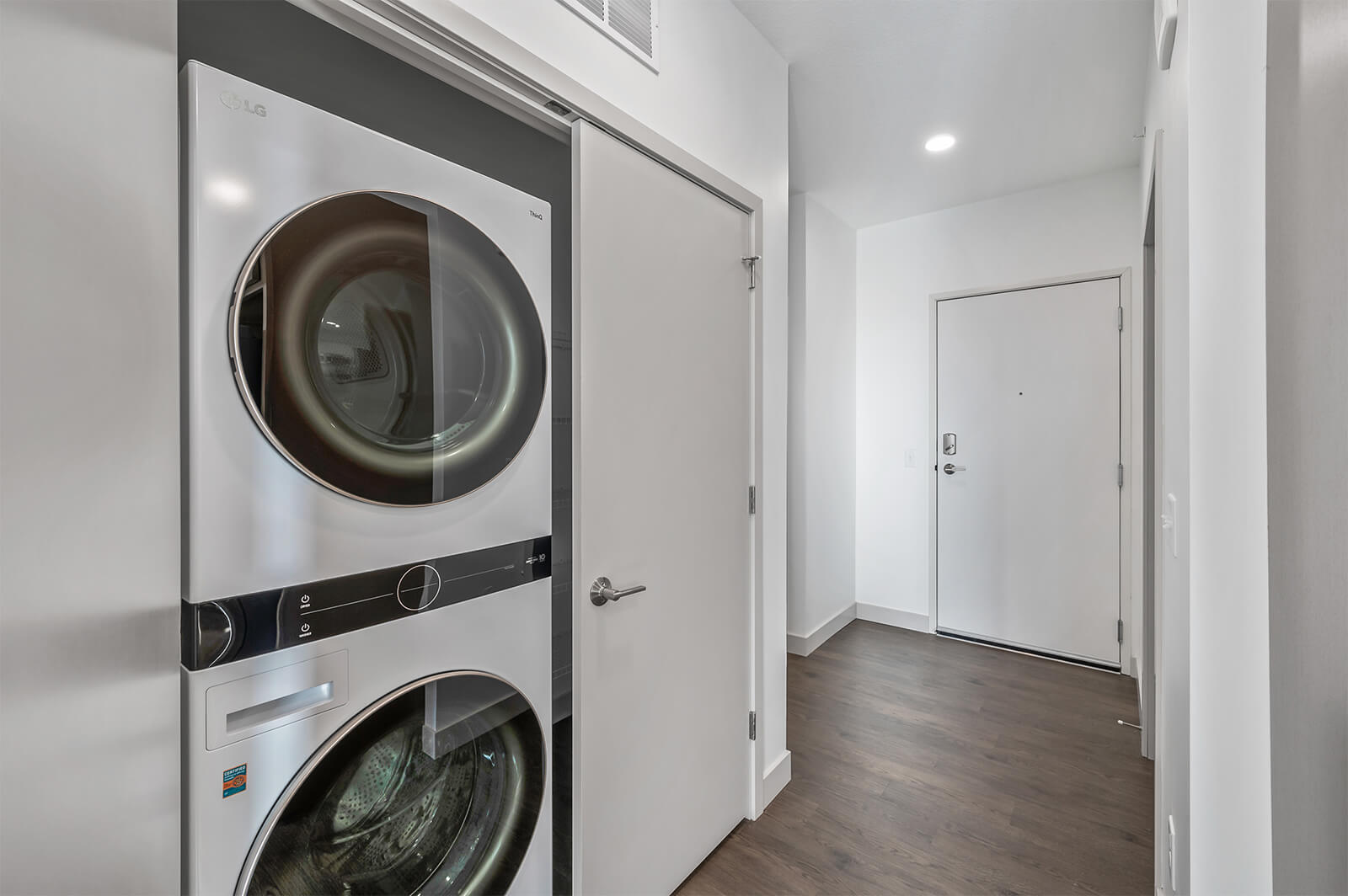 Laundry area with stacked LG washer and dryer in hallway closet