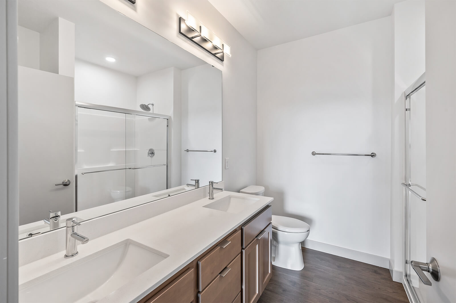 Bathroom with double vanity and glass-enclosed shower