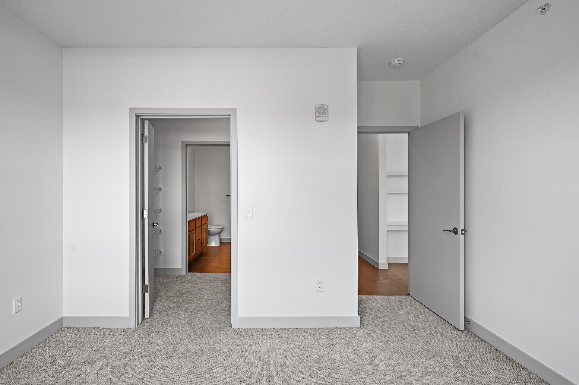 Bedroom view showing two doorways leading to closet and bathroom.