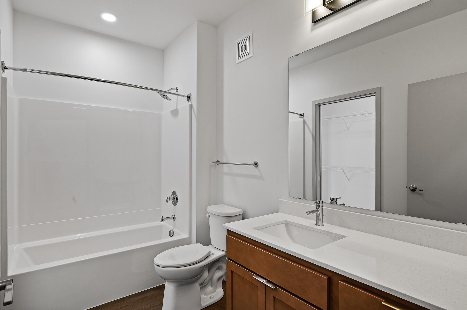 Bathroom with shower, modern fixtures, and wood floors.