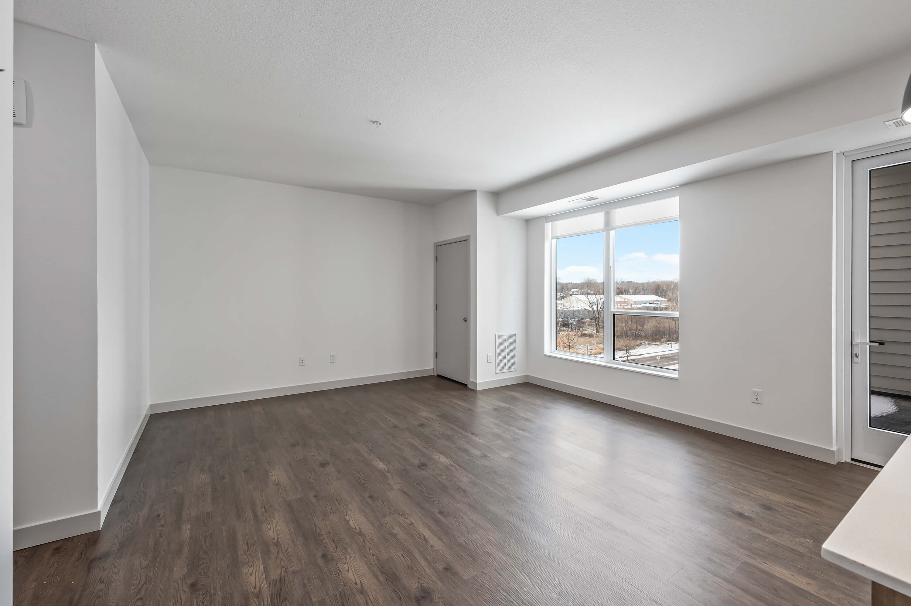 Living area with large windows providing natural light and a view of the outdoors.