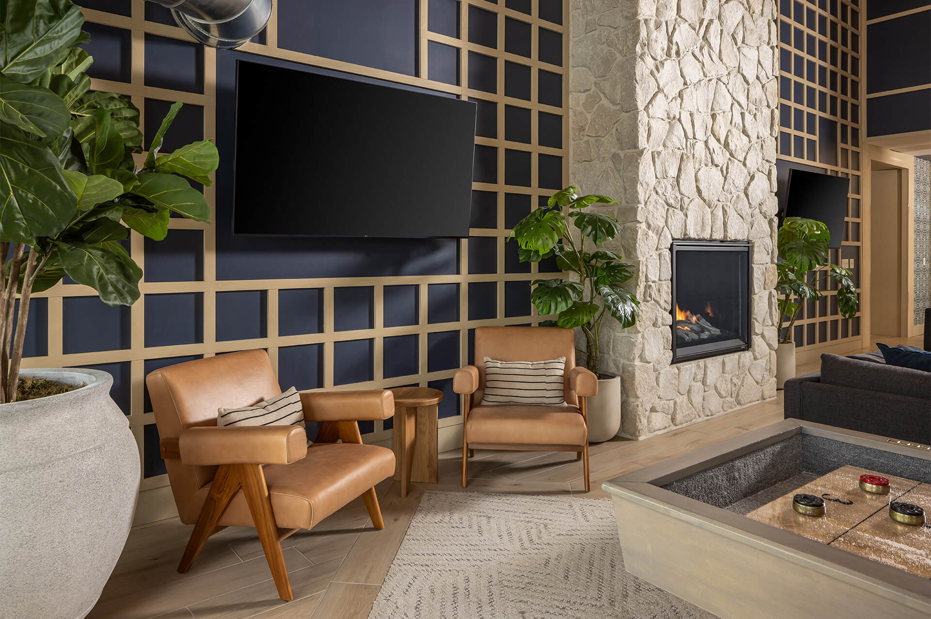Cozy clubroom at The Harlan Oakdale featuring a fireplace and lounge chairs