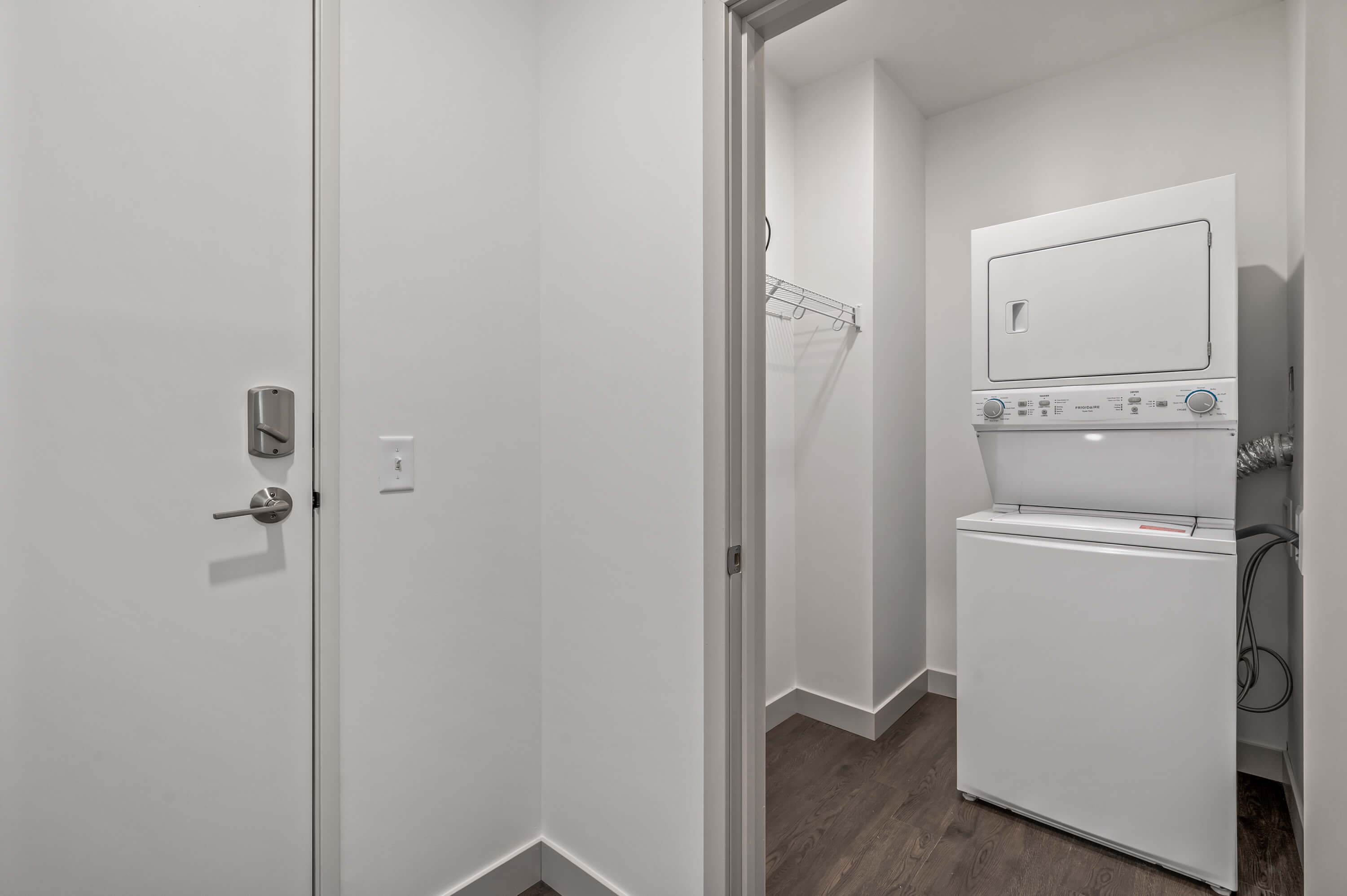 Laundry area featuring a stacked washer and dryer unit with an adjacent closet.